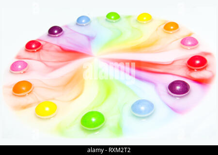 Die Bonbons lösen sich im Wasser und bilden eine bunte Show. Stockfoto