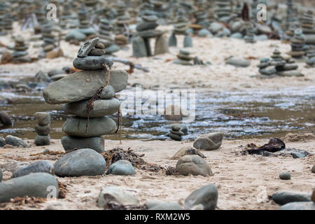 Kieselsteine an der Küste. Kleine Cairn auf dem Hintergrund des Meeres. Landschaft für die Meditation. Stockfoto