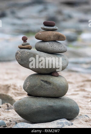 Kieselsteine an der Küste. Kleine Cairn auf dem Hintergrund des Meeres. Landschaft für die Meditation. Stockfoto