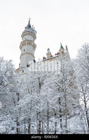 Schloss Neuschwanstein im Winter Landschaft. Ein 19.-Jahrhundert Neoromanischen Palast auf einem zerklüfteten Hügel oberhalb des Dorfes in der Nähe von Hohenschwangau Fü Stockfoto