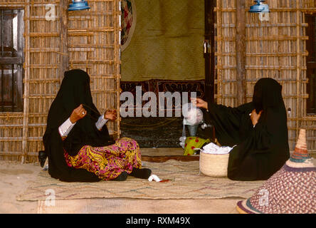 Arabische Folklore und Geschichte mit Emiratische Beduinenfrauen demonstrieren die Kunst des Webens silber Braid während des Dubai Handel Festival in den Vereinigten Arabischen Emiraten Stockfoto