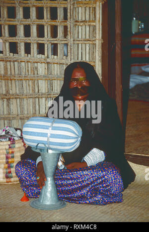 Arabische Folklore und Geschichte mit einem Emiratischen Beduinenfrauen demonstrieren die Kunst des Webens silber Braid während des Dubai Handel Festival in den Vereinigten Arabischen Emiraten Stockfoto