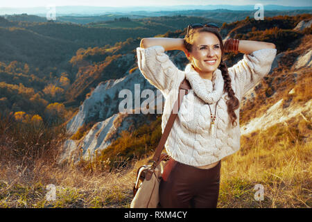 Entspannt, junge Reisende Frau in Wanderkleidung mit Beutel genießen Sie im Sommer die Toskana Aussicht genießen Promenade. Stockfoto