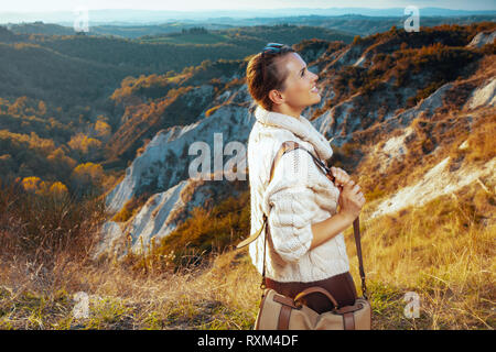 Glückliche junge touristische Frau in Wanderausrüstung mit Tasche auf Sommer Wandern in der Toskana, Italien, Promenade genießen. Stockfoto