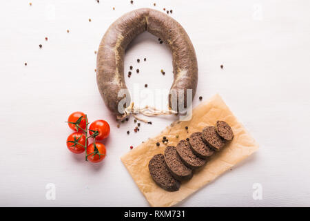 Lebensmittel, Fleisch und leckeren Konzept - Würstchen mit Pferdefleisch mit Tomaten auf dem Tisch gemacht Stockfoto