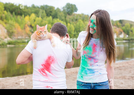 Pet, Sommertourismus, festival Holi und Natur Konzept - Lustiger Mann und Frau mit Katze auf natürliche Hintergrund Stockfoto