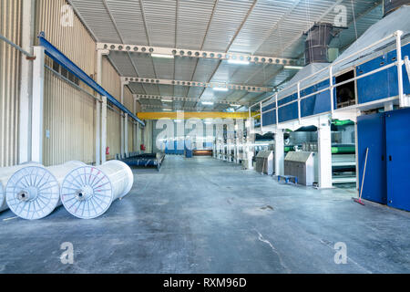 Innenraum der Textilfabrik mit automatischen Maschinen. Konzept der Industrie und Technologie