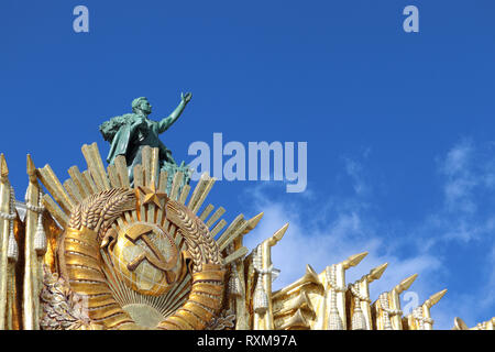 Sowjetische Symbole, UDSSR Wappen und Skulptur eines Arbeitnehmers auf der Fassade der Zentrale Pavillon auf Vdnh in Moskau gegen den blauen Himmel an einem sonnigen Tag Stockfoto