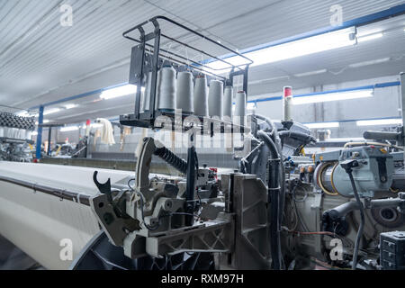 Innenraum der Textilfabrik mit automatischen Maschinen. Konzept der Industrie und Technologie