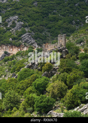 Stein Turm Ruinen auf einem steilen felsigen Klippen mit Bäumen in der Mani, Griechenland. Stockfoto
