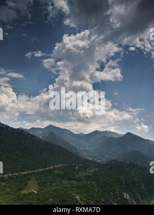 Gebirge mit vielen Spitzen unter einem Himmel mit Wolken Formationen Stockfoto