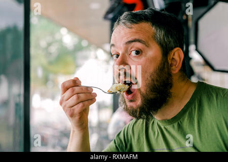 Die hungrigen Mann, ein Süßes isst Stockfoto