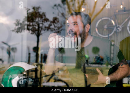 Der hungrige Mann, der eine Süßigkeit isst Stockfoto