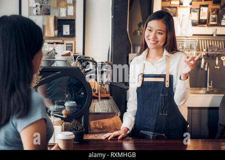 Frau Barista im Gespräch mit dem Kunden über schmeckt der Kaffee Tasse mit glücklichen Gefühl an der Theke bar Cafe. coffee shop Business Owner Konzept, Service mi Stockfoto