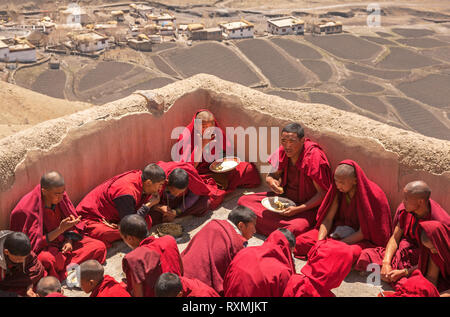 SPITI, INDIEN - 28. APRIL 2016: Gruppe junger Mönche Üben der tibetische Buddhismus haben das Frühstück auf dem Dach der wichtigsten Kloster in Spiti, Indien auf der Apr Stockfoto