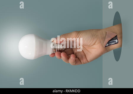 Hand lightbulp Witz Einsetzen der Batterie in den Arm, die Idee Konzept. Stockfoto