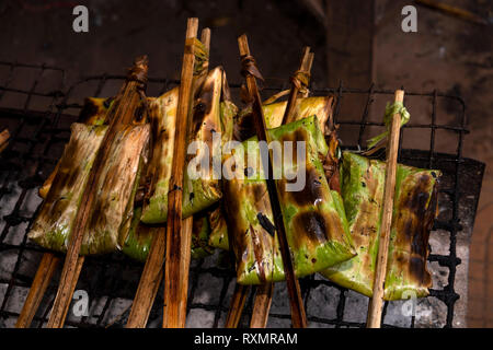 Kambodscha, Phnom Penh, Oudong, Lebensmittelmarkt, Grillen Pakete von klebrigen Reis im pandanus gewickelt Leaved Stockfoto