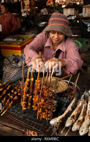 Kambodscha, Phnom Penh, Oudong, Lebensmittelmarkt, Bush Fleisch ausgeht, Frau verkaufen kleine Vögel über Holzkohle Grill zubereitet Stockfoto