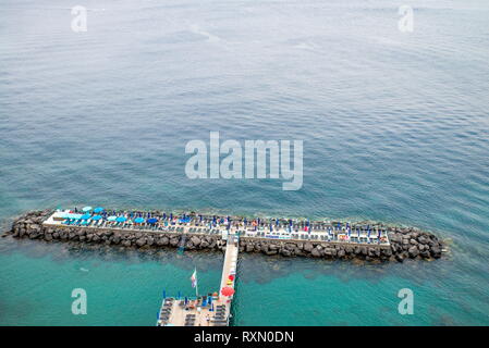 Neapel, Sorrent, Italien - 10 August 2015: ein Blick von oben auf die Strände von Sorrent. Sie können sehen, Strand von Steinen mit vielen bunten Liegestühle Stockfoto