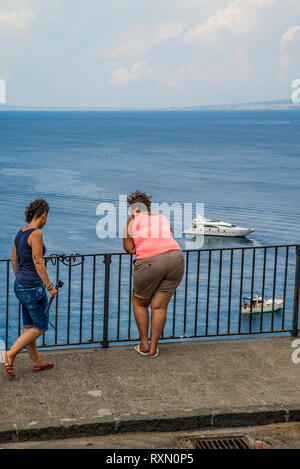 Neapel, Sorrent, Italien - 10 August 2015: ein Blick von oben auf die Strände von Sorrent. Eine rundliche Frau schaut auf das Meer und die Schiffe. Stockfoto