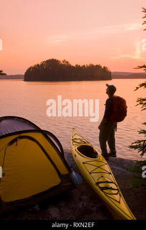 Mann neben Kajak, Zelt, Französisch See, Quietico Provincial Park, Ontario, Kanada Stockfoto