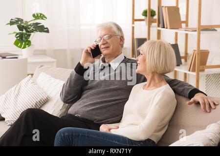 Ältere Menschen am Telefon sprechen sich zurückzog, Rest mit Frau Stockfoto