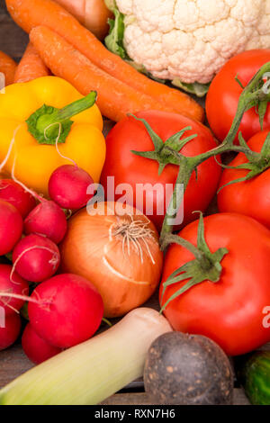 Nahaufnahme von rohem Gemüse, Tomaten, Karotten, Paprika, Zwiebeln, Kartoffeln, Blumenkohl, Porree, Gurken. Stockfoto