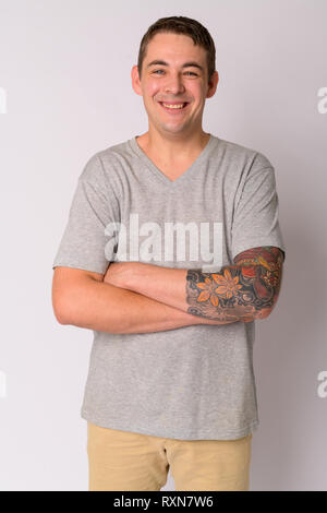 Portrait von Happy stattlicher Mann mit Tätowierungen lächelnd und Kreuzung Arme Stockfoto
