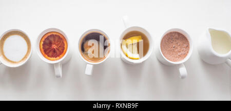 Warme Getränke Kaffee und Tee in Weiß Cups stehen in einer Linie auf einem weißen Tisch. Ansicht von oben, flach Stockfoto