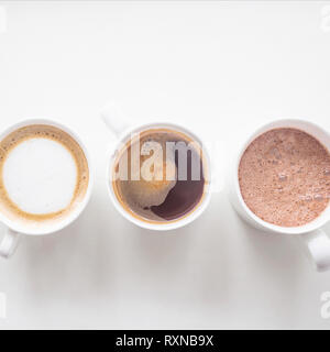 Kaffee, Cappuccino und Kakao in Weiß cups auf einem weißen Hintergrund. Drei Getränke. Ansicht von oben, flach Stockfoto