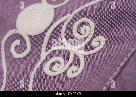 Weiße Stickerei auf Violett Textil, Kleid detail Stockfoto