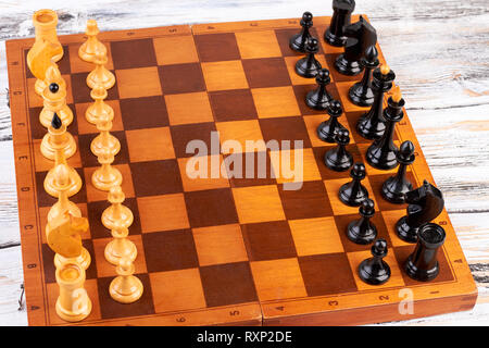 Holz- Schachfiguren auf Schachbrett platziert. Stockfoto