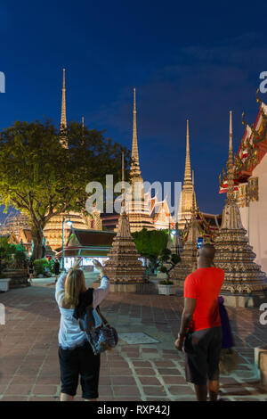 Touristen machen Fotos von buddhistischen Tempel Phra Maha Chedi in der Nacht, Bangkok, Thailand Stockfoto