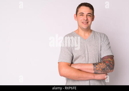 Portrait von Happy stattlicher Mann mit Tätowierungen lächelnd und Kreuzung Arme Stockfoto