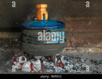 Eine traditionelle Südafrikanische potjiekos Schüssel über einem offenen Feuer vorbereitet wird. Stockfoto