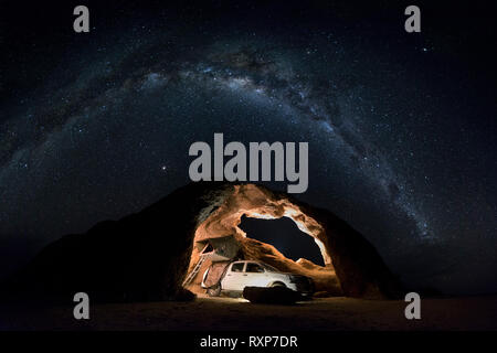 Ein Camping 4x4 in einem Rock arch in Namibia unter der Milchstraße Bug Stockfoto