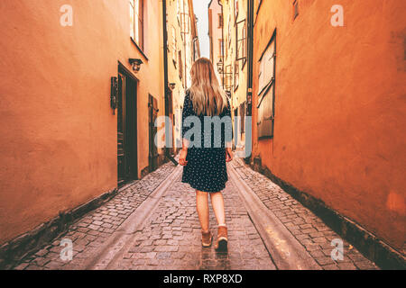 Junge Frau alleine zu Fuß unterwegs in Stockholm reisen Sommerferien in Schweden Altstadt Straße mit Kopfsteinpflaster Stockfoto