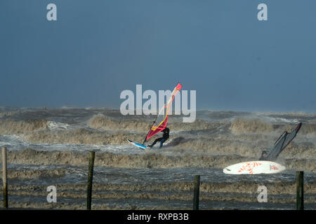 März 2019 - Windsurfen Kerle in die raue See bei Weston super Mare, England. Stockfoto