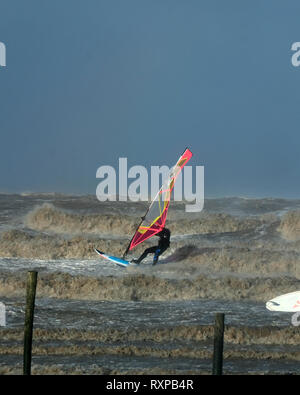 März 2019 - Windsurfen Kerle in die raue See bei Weston super Mare, England. Stockfoto