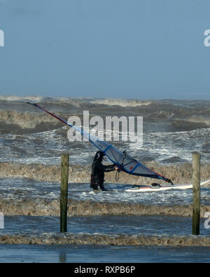 März 2019 - Windsurfen Kerle in die raue See bei Weston super Mare, England. Stockfoto