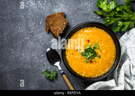 Rote Linsensuppe auf schwarz Ansicht von oben. Stockfoto