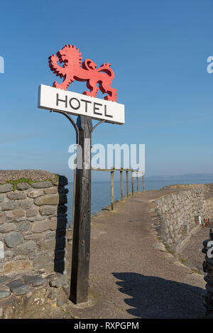 Clovelly, Devon, England, UK, März 2019. red Hotel Schild montiert auf einer alten Eiche post an der Küste in Clovelly. Stockfoto