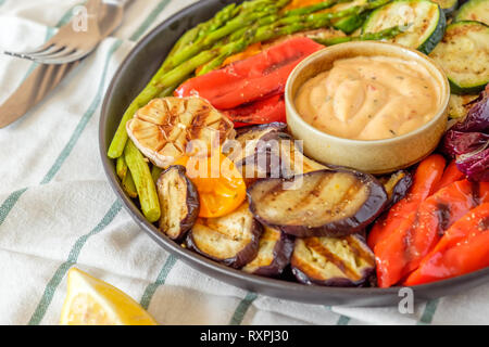Gegrilltes Gemüse auf einem Teller mit Sauce, selektiven Fokus. Stockfoto