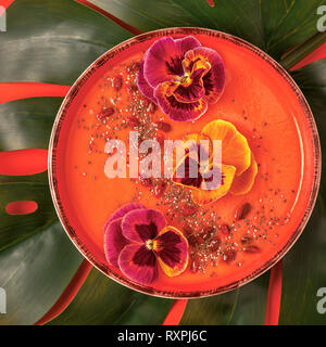 Smoothie Schüssel mit essbaren Stiefmütterchen Blumen, Chia Samen, Goji Beeren, Ansicht von oben. Stockfoto