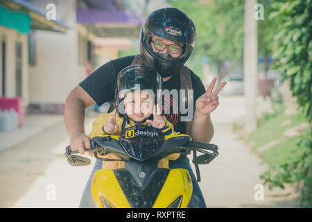 KANCHANABURI THAILAND - 10. Oktober: Unidentiffied Vater und sein Sohn, ein Motorrad zu fahren Fahren. am Oktober 10,2018 an Watkrangthongratburana Schule in Stockfoto