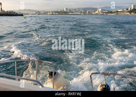 Wellen und Schaum Achteraus der Yacht bei der Ausfahrt aus dem Hafen. Stockfoto