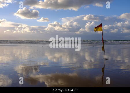 RNLI Fahnen Rot und Gelb und mit dramatischen Himmel Stockfoto