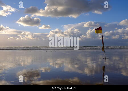 RNLI Fahnen Rot und Gelb und mit dramatischen Himmel Stockfoto