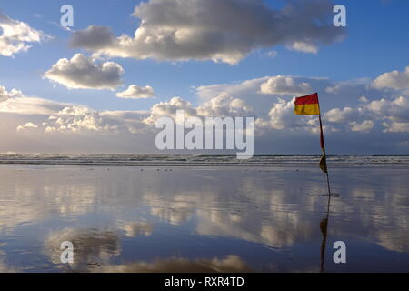 RNLI Fahnen Rot und Gelb und mit dramatischen Himmel Stockfoto