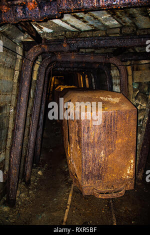 Alten verrosteten Wagen in der verlassenen Mine Tunnel mit hölzernen Holzausbau Stockfoto